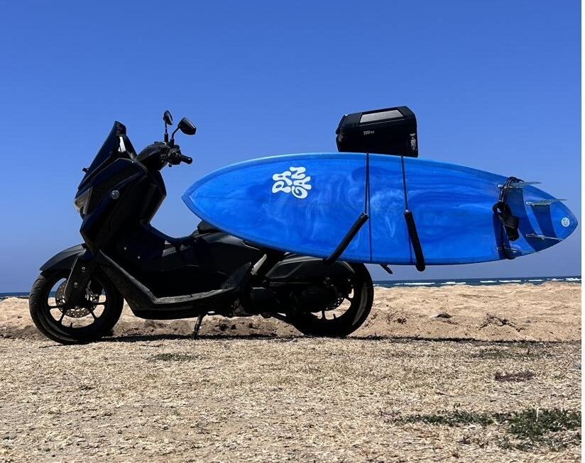 Blue board loaded on the bike at the beach