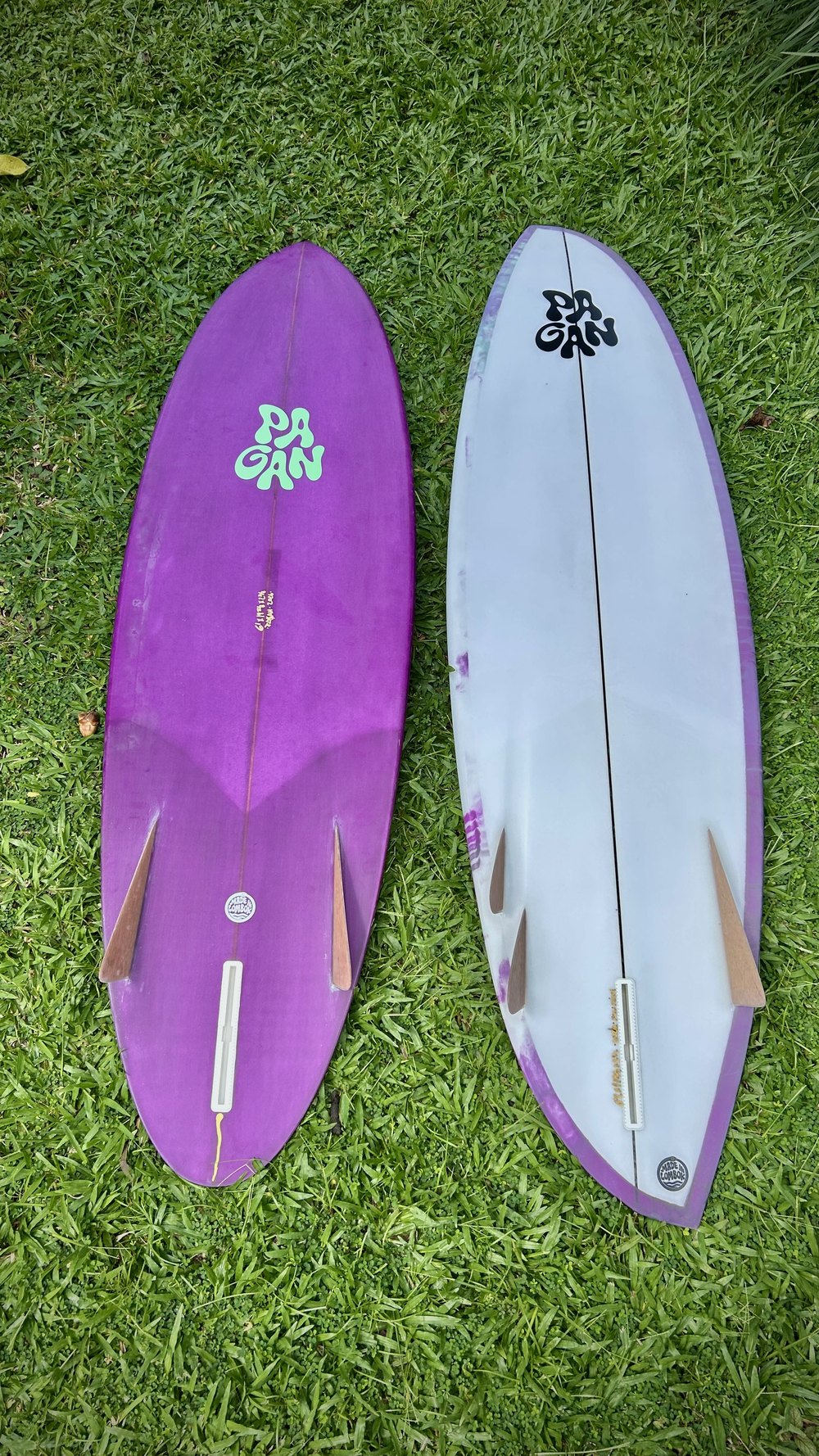 Two boards laid out fins up on the grass