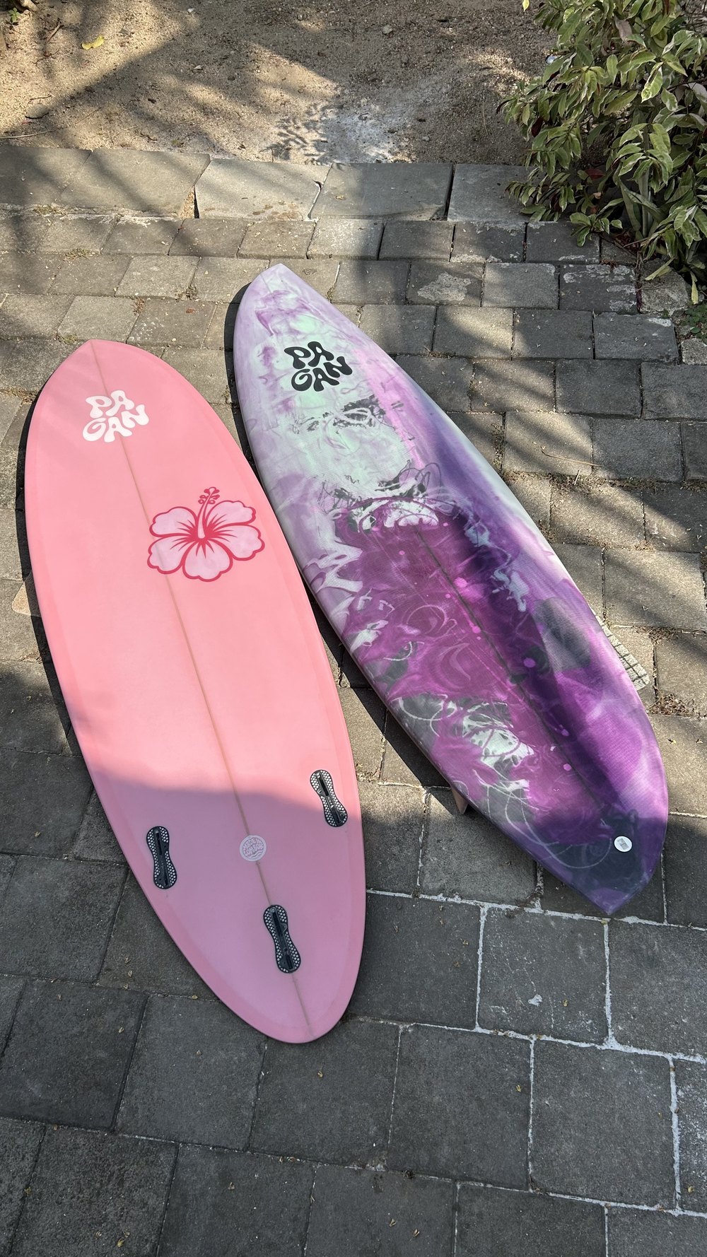 A pink and a purple board on the paving